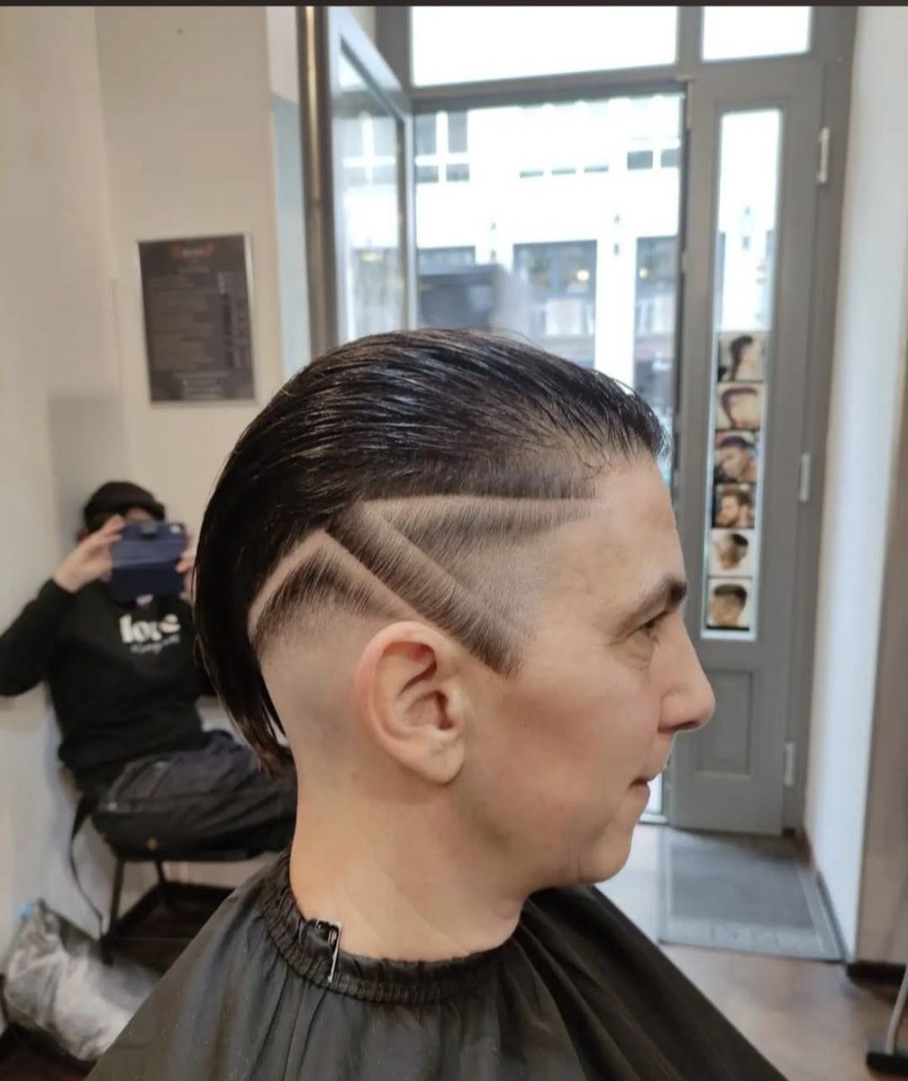 Men's side part with a shaved triangle design fade